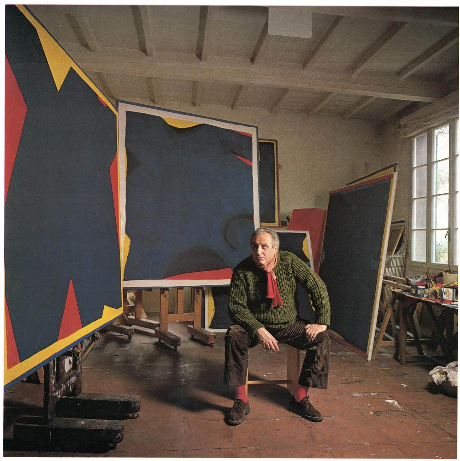 Arturo Carmassi ritratto con delle sue opere nel suo studio